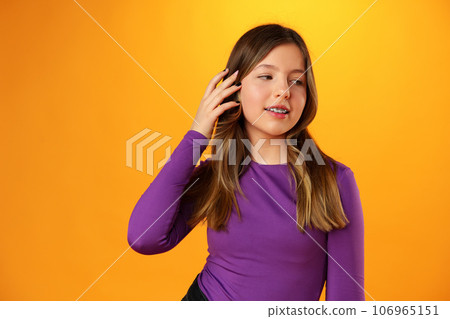 Photo of teen girl smiling portrait against yellow background in studio 106965151