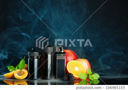 Vape and smoking liquid with fruit against black background with smoke 106965155