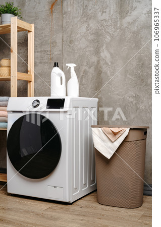 Washing machine in a gray modern laundry room 106965337