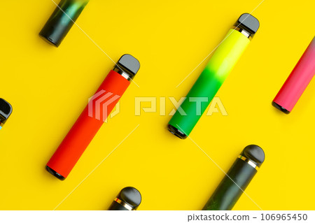 Colorful disposable electronic cigarettes on yellow background Colorful disposable electronic cigarettes on yellow background 106965450