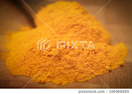 Ground turmeric in a spoon Ground turmeric in a spoon 106966889