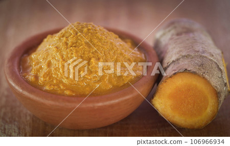 Mashed turmeric in a clay bowl Mashed turmeric in a clay bowl 106966934
