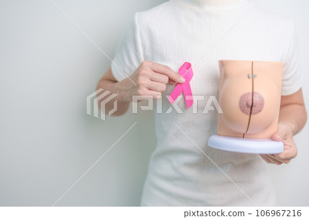 Pink October Breast Cancer Awareness month, woman with pink Ribbon and Breast Anatomy model. National cancer survivors month, health diagnosis, Mother and World cancer day concept Pink October Breast Cancer Awareness month, woman with pink Ribbon and Breast Anatomy model. National cancer survivors month, health diagnosis, Mother and World cancer day concept 106967216