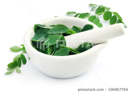 Edible moringa leaves with mortar and pestle 106967768