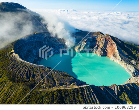 Aerial view of rock cliff at Kawah Ijen volcano with turquoise sulfur water lake at sunrise.Amazing nature landscape view at East Java, Indonesia. Natural landscape background 106968299