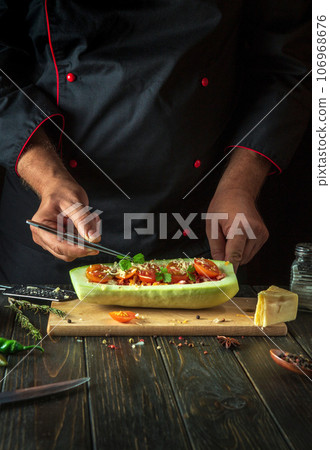 The cook adds parsley to stuffed zucchini with meat and vegetables. The concept of cooking national stuffed zucchini or mahshi for dinner. Copy space The cook adds parsley to stuffed zucchini with meat and vegetables. The concept of cooking national stuffed zucchini or mahshi for dinner. Copy space 106968676
