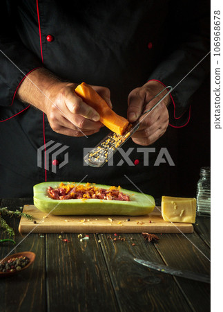 The chef adds carrot to zucchini. The concept of cooking a national Stuffed squash boat or marrow in a restaurant kitchen. Free space for menu The chef adds carrot to zucchini. The concept of cooking a national Stuffed squash boat or marrow in a restaurant kitchen. Free space for menu 106968678
