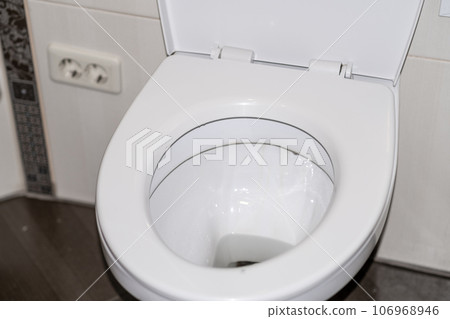 White toilet bowl in the toilet in the bathroom. The toilet before it is washed. The concept of cleaning and cleanliness. White toilet bowl in the toilet in the bathroom. The toilet before it is washed. The concept of cleaning and cleanliness. 106968946