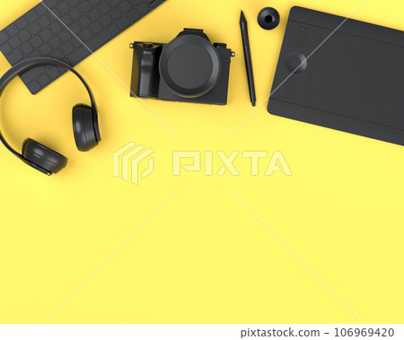 Top view of monochrome designer workspace and photography gear on yellow 106969420