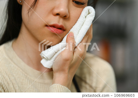 Sick young wiping her face with wet towel for reduce high fever. Illness and health care concept Sick young wiping her face with wet towel for reduce high fever. Illness and health care concept 106969603