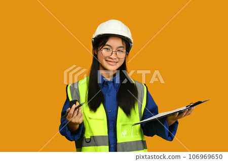 Future dream job career as engineer and architect. Smiling Asian girl holding helmet isolated on yellow background 106969650