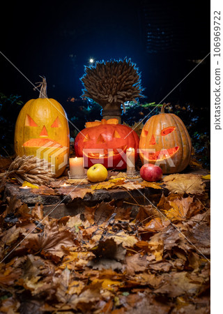 Halloween pumpkin with candle closeup in dark forest. Halloween festive background 106969722
