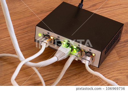 The back panel of a small home switch with interface cables connected. Tcp ip network business The back panel of a small home switch with interface cables connected. Tcp ip network business 106969736
