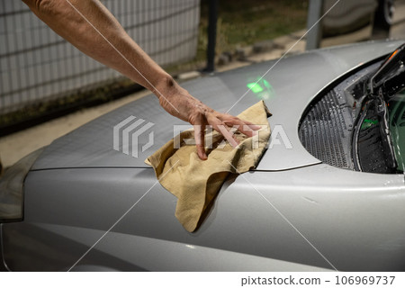 Worker cleaning silver car closeup. Car detailing series 106969737