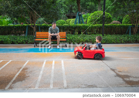 Little boy is riding in a remote controlled car Little boy is riding in a remote controlled car 106970004