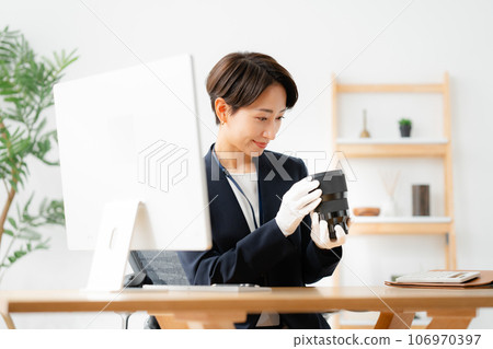 A store clerk assessing camera lenses 106970397