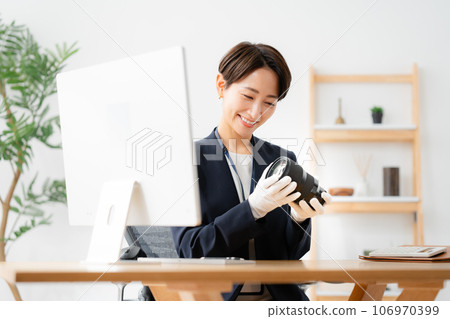 A store clerk assessing camera lenses 106970399