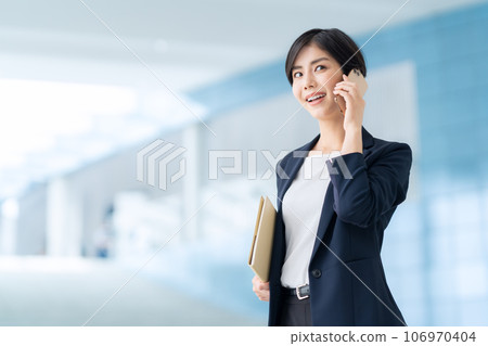 年輕女商人在辦公室打電話用智能手機 106970404