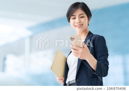 年輕女商人在辦公室打電話用智能手機 106970406
