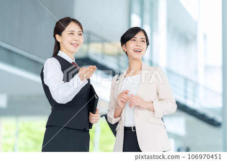 接待員在辦公室大堂指導一位年輕女商人 106970451