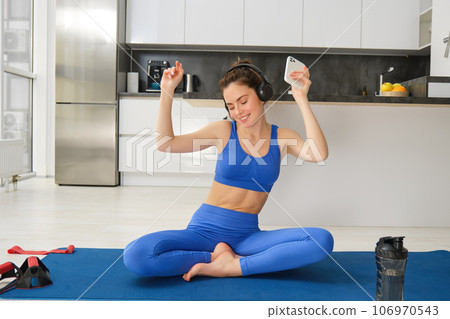 Dancing happy woman, workout from home on rubber yoga mat, having fun while training alone indoors with music Dancing happy woman, workout from home on rubber yoga mat, having fun while training alone indoors with music 106970543