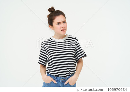 Portrait of confused young woman, looking with disbalief, raising her eyebrows and staring shocked at camera, standing over white background Portrait of confused young woman, looking with disbalief, raising her eyebrows and staring shocked at camera, standing over white background 106970684