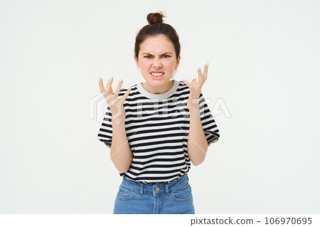 Image of angry woman shouts and shakes hands, stands in casual clothes over white background Image of angry woman shouts and shakes hands, stands in casual clothes over white background 106970695