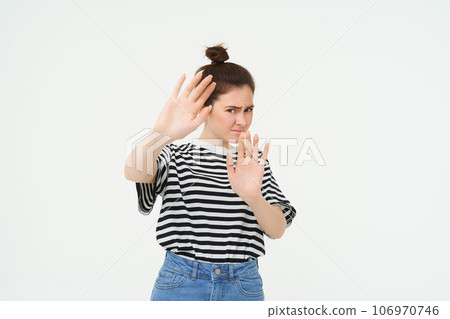 Image of woman refusing something, raising hands in defensive gesture, protecting herself, rejecting offer, declining, standing over white background 106970746