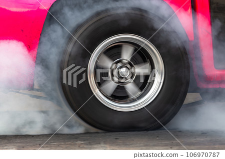 Close up car wheel with smoke on the asphalt road speed track, Car wheel drifting and smoking on track, Car wheel spinning. Close up car wheel with smoke on the asphalt road speed track, Car wheel drifting and smoking on track, Car wheel spinning. 106970787