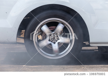 Close up car wheel with smoke on the asphalt road speed track, Car wheel drifting and smoking on track, Car wheel spinning. Close up car wheel with smoke on the asphalt road speed track, Car wheel drifting and smoking on track, Car wheel spinning. 106970801