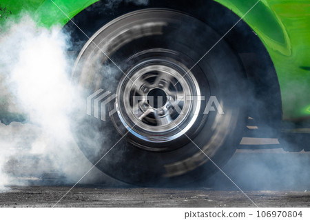Close up car wheel with smoke on the asphalt road speed track, Car wheel drifting and smoking on track, Car wheel spinning. Close up car wheel with smoke on the asphalt road speed track, Car wheel drifting and smoking on track, Car wheel spinning. 106970804