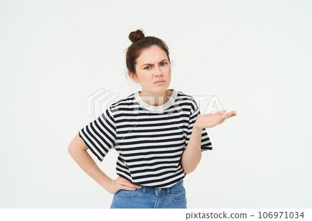 Image of frustrated woman complaining, looking puzzled, shrugging and frowning, standing over white background 106971034