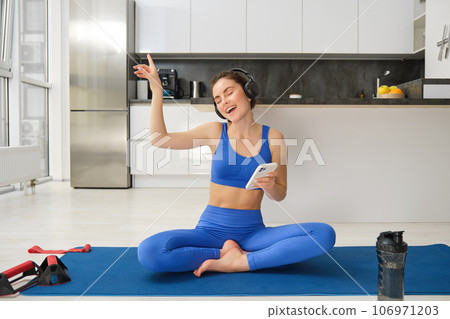 Dancing happy woman, workout from home on rubber yoga mat, having fun while training alone indoors with music Dancing happy woman, workout from home on rubber yoga mat, having fun while training alone indoors with music 106971203