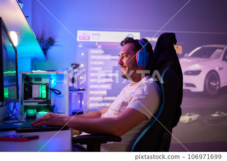 Player looking at his computer screen, contemplating his next move in an online video game. Player looking at his computer screen, contemplating his next move in an online video game. 106971699