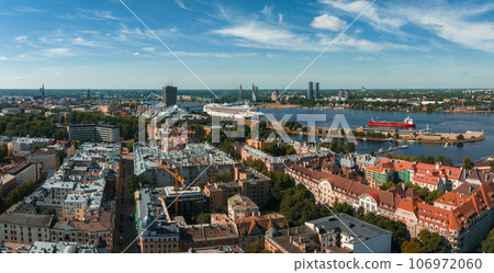 Summer sunset in Riga, Latvia. Aerial view of Riga, the capital of Latvia at sunset. Beautiful buildings, bridges and transport going through the city. Summer sunset in Riga, Latvia. Aerial view of Riga, the capital of Latvia at sunset. Beautiful buildings, bridges and transport going through the city. 106972060