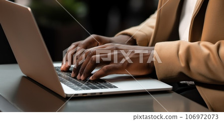 Close-up hands of an African American businessman works with laptop at sidewalk cafe. 106972073
