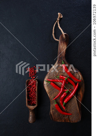 Red chili peppers on a wooden chopping board. Fresh chili peppers. Red hot chili pepper.Flat lay. Top view. Copy space.Vertical photo. Red chili peppers on a wooden chopping board. Fresh chili peppers. Red hot chili pepper.Flat lay. Top view. Copy space.Vertical photo. 106972139