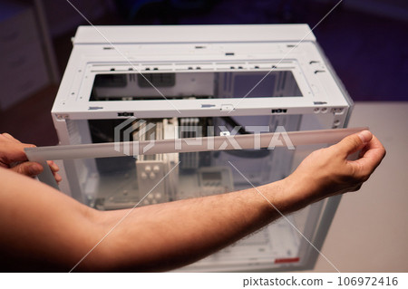 Close-up of technician's hand assembling personal computer. 106972416