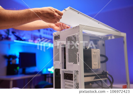 Close-up of technician's hand assembling personal computer. 106972423