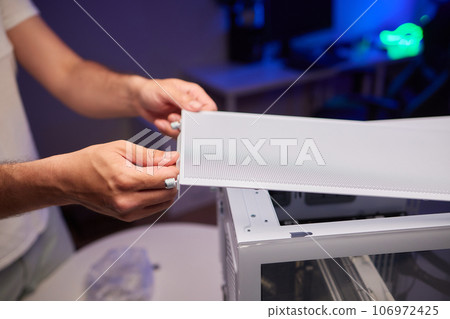 Close-up of technician's hand assembling personal computer. Close-up of technician's hand assembling personal computer. 106972425