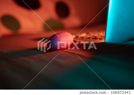 toys for sex on a laptop on a bright neon background. 106972441