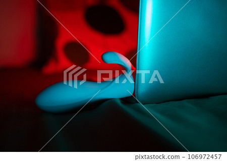 toys for sex on a laptop on a bright neon background. toys for sex on a laptop on a bright neon background. 106972457