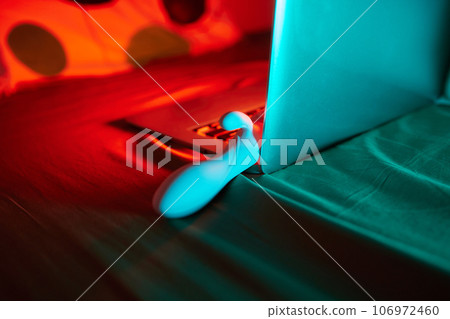toys for sex on a laptop on a bright neon background. toys for sex on a laptop on a bright neon background. 106972460