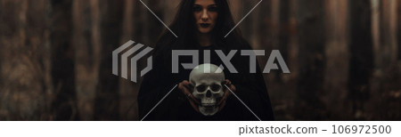 black terrible witch holds the skull of a dead man in her hands black terrible witch holds the skull of a dead man in her hands 106972500