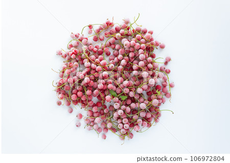 Frozen red currant berries laid out in the shape of a circle on a white background. 106972804