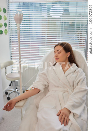 A swab is pressed onto the injection site during the blood collection. A swab is pressed onto the injection site during the blood collection. 106972895