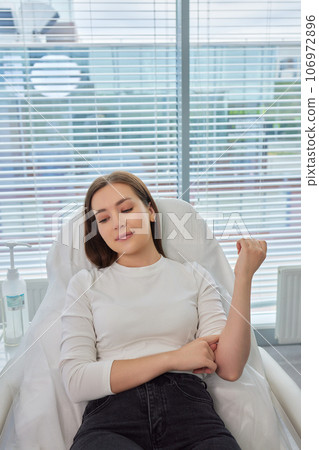 A swab is pressed onto the injection site during the blood collection. A swab is pressed onto the injection site during the blood collection. 106972896