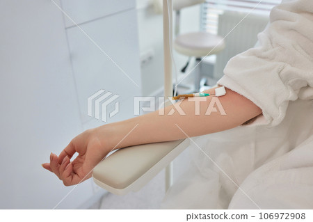 A swab is pressed onto the injection site during the blood collection. A swab is pressed onto the injection site during the blood collection. 106972908