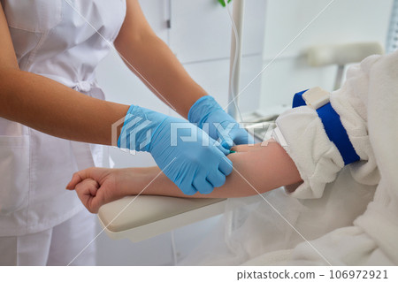 A swab is pressed onto the injection site during the blood collection. 106972921