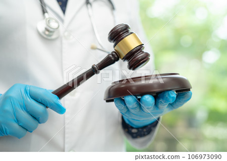 Doctor holding judge gavel, forensic medicine, medical law and crime justice concept. Doctor holding judge gavel, forensic medicine, medical law and crime justice concept. 106973090